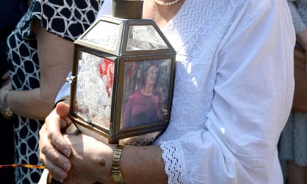 A woman holds a lantern with a picture of murdered journalist Daphne Caruana Galizia during a protest demanding justice.