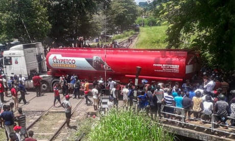 Fuel truck parked across the railway tracks and crowd around it