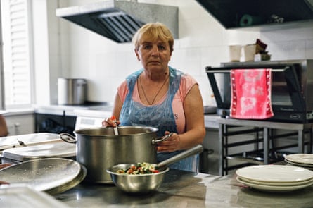A women in an apron in an industrial kitchen.