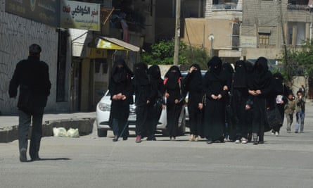 Female school students wearing niqabs, which Isis have decreed that women must wear in public at all times.