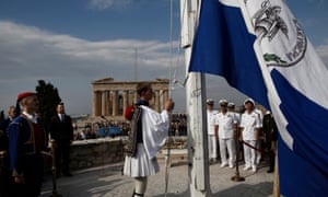 A presidential guard raises the historical Greek flag during a ceremony to mark the 74th anniversary of the liberation of Athens from Nazi occupation