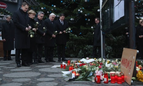 Angela Merkel and other German politicians lay flowers near the spot where a truck ploughed through a Christmas market in Berlin