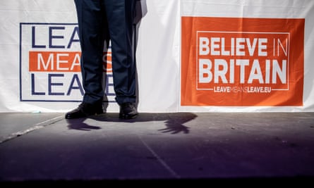 A man's legs in front of Leave Means Leave and Believe in Britain banners