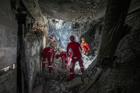 Recuers search through the rubble of a damaged section of Evin Prison following the Israeli airstrike.