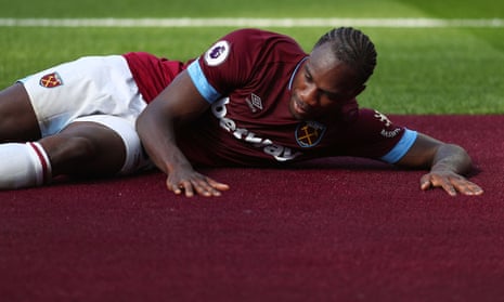 Michail Antonio of West Ham United rubs the new claret carpet that surrounds the pitch in celebration after scoring the opening goal.