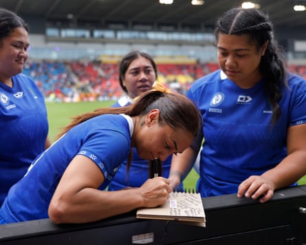The Samoa centre Keilamarita Pouri-Lane writes a message in a book for a disabled supporter after the Women’s Rugby World Cup 2025 Group A match between Australia and Samoa.
