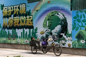 A migrant worker listens to the radio on his tricycle cart.