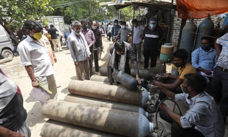People queue to refill oxygen cylinders in New Delhi, India, 23 April.
