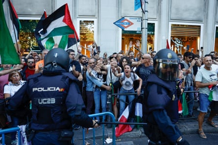 Protesters scream at police in Madrid.