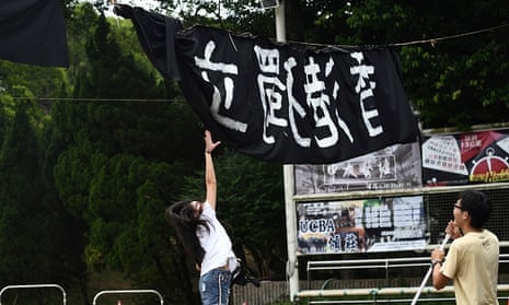 A woman tries to untangle a banner calling for independence, at the Chinese University of Hong Kong campus in Hong Kong. Universities have become the latest battleground over freedom.