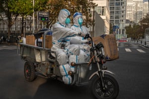 Beijing, China. Epidemic control workers wear protective clothing to protect against the spread of COVID-19 after the local government closed several shops, stopped inside dining in restaurants, switched schools to online studies and asked people to work from home