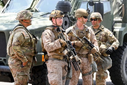 US marines work next to members of the California national guard outside a federal building 0n 13 June in Los Angeles.