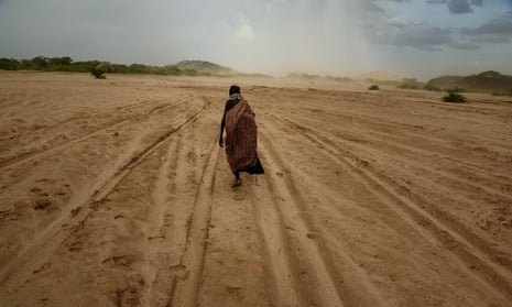 A woman walks across a dry riverbed in Turkana, Kenya.
