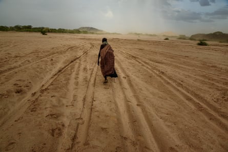 A woman walks across a dry riverbed in Turkana, Kenya on 18 October 2017