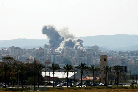 View of a distant city with large cloud of smoke rising in the sky.