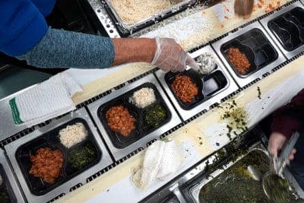 a woman scooping putting food in containers