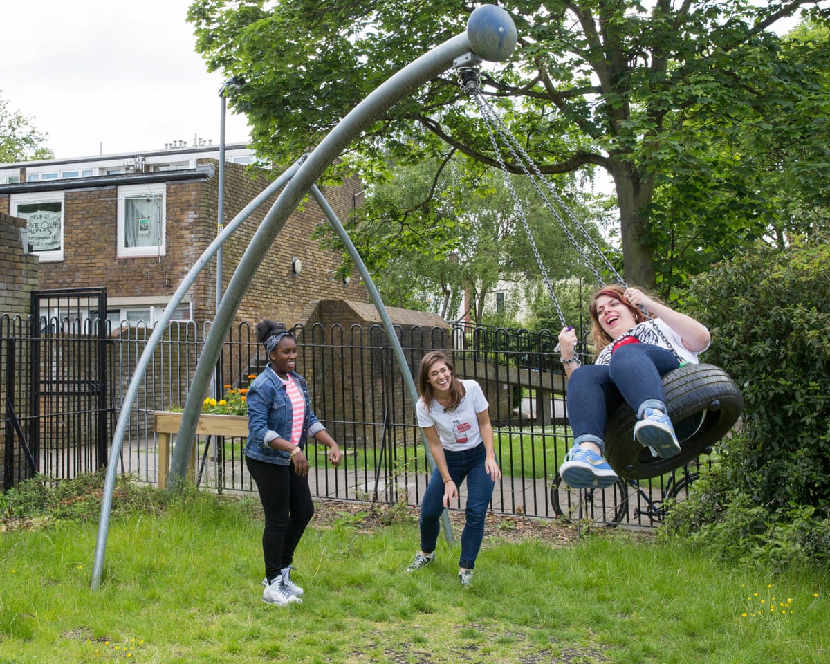 Three children play on a swing