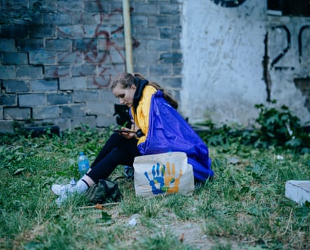A woman sits out in the open in the aftermath of the airstrike