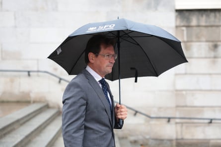 He walks down wide stone steps under an umbrella
