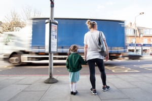 Child standing near road with truck going past