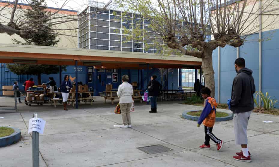 Families socially distance at the West Oakland Middle school. The city’s school board has voted to eliminate the district’s police department.