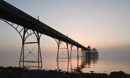 Clevedon’s ironwork pier almost silhouetted against dusky pink sea and skies