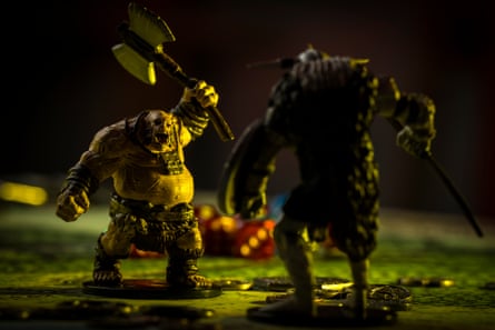 Close up on D&D figures owned by Luke Breen showing an ogre brandishing an axe and a figure in shadow in the foreground. Dice are pooled in the background