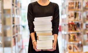 A woman holding a stack of books