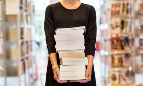 File photo of a young woman holding books in a library