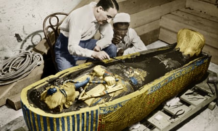 The British archeologist Howard Carter and an Egyptian assistant examine the sarcophagus containing the body of the pharaoh Tutankhamun in the Valley of the Kings, Egypt.