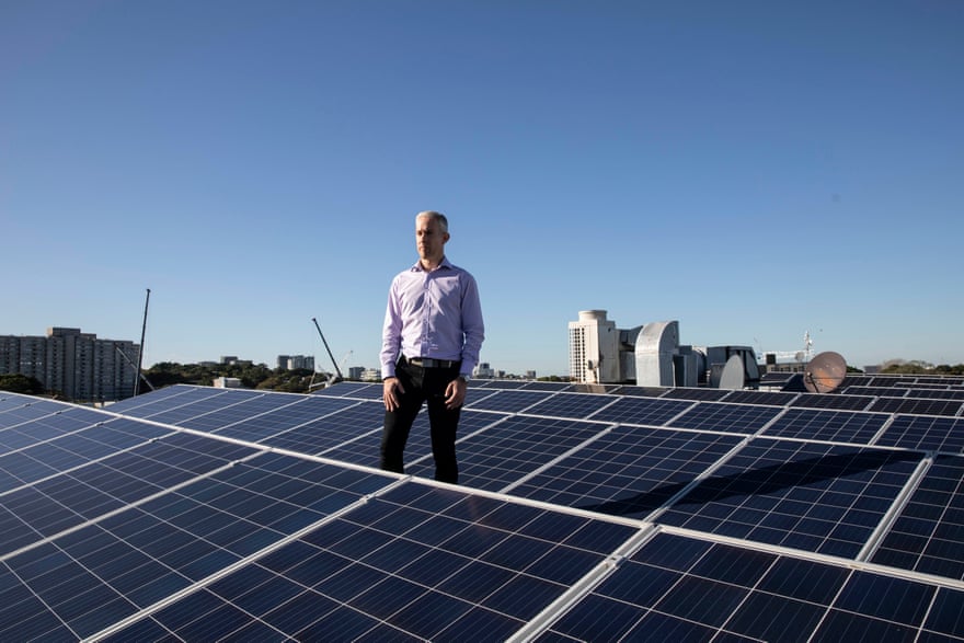 Nathan Hage stands on the roof of the Zinc Building in Alexandria, which is about to double its solar capacity and install a battery system