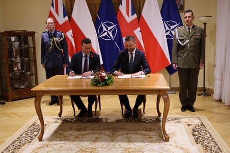 O ministro da defesa polonês WÅ‚adysÅ‚aw Kosiniak-Kamysz (à direita) com Wes Streeting assinando o Pacto de Defesa de Varsóvia.