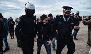 Police officers arrest a woman for trying to throw a cross into the sea in Thessaloniki, as Greek bishops’ determination to keep churches open for today’s Epiphany holiday in the face of a coronavirus lockdown have stepped up a confrontation with the government over health restrictions