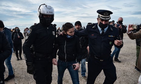 Police officers arrest a woman for trying to throw a cross into the sea in Thessaloniki, as Greek bishops’ determination to keep churches open for today’s Epiphany holiday in the face of a coronavirus lockdown have stepped up a confrontation with the government over health restrictions