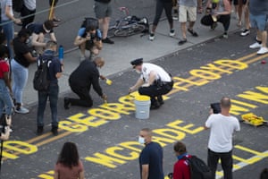 Capt. William Fisher of the 26th District of the Philadelphia police joins in the painting of “End Racism Now” and victims’ names
