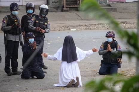 Sister Ann Rose Nu Tawng kneels in front of armed police