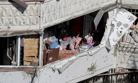 A resident inspects her belongings in a damaged residential building after a Russian drone attack in Odessa.