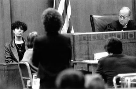 A black and white image of a woman testifying at a trial in front of a judge