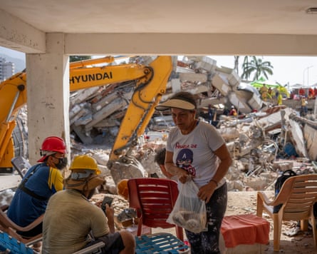 Olivia Sandoval hands out traditional flatbread to rescuers near a collapsed building where she hopes they will find her grandson Ronald.