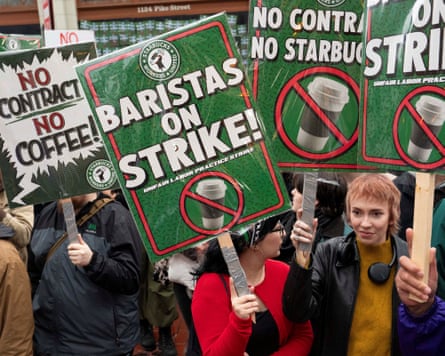 Starbucks employees hold placards. One reads: ‘baristas on strike’