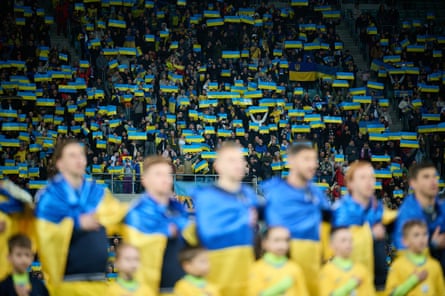Người hâm mộ Ukraine trưng bày lá cờ của đất nước họ khi các cầu thủ xếp hàng hát quốc ca trước chiến thắng chung cuộc play-off Euro 2024 trước Iceland.