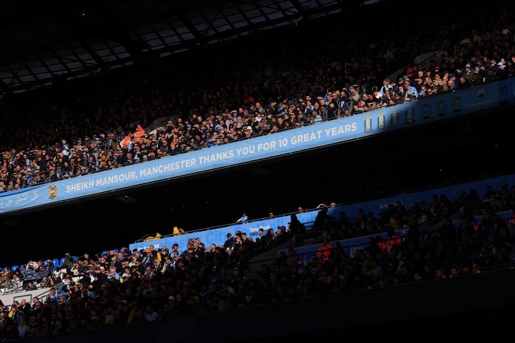 Crowded Manchester City stadium stands under a banner thanking Sheikh Mansour for ten great years