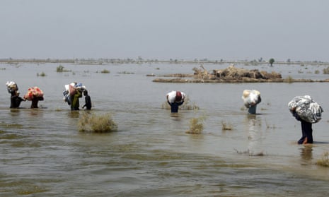 Relief aid being carried through flood water in Sindh province, Pakistan, 9 September 2022. 