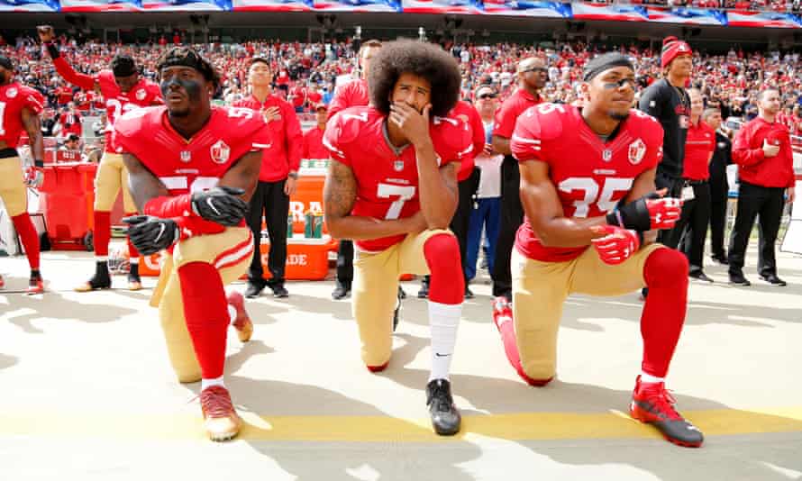 San Francisco 49er Colin Kaepernick and two teammates take a knee during the US national anthem before an NFL game in 2016.