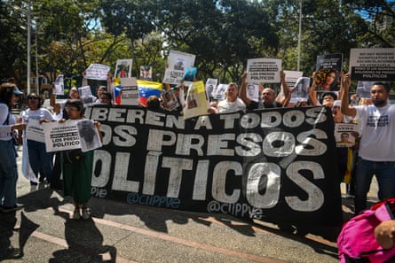 a group of people hold a banner that reads “Release all political prisoners”