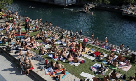 People enjoy hot summer weather on the banks of the Limmat river in Zurich, Switzerland on 27 June 2020, as the spread of coronavirus continues.