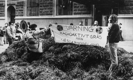 Two demonstrators hold a protest banner on a heap of hay dumped outside government headquarters in 1986