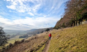 Female walker in red coat rambling on Ranmore Common