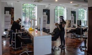 Parrucchieri, protetti da maschere e scudi, al lavoro a Milano, in Lombardia, il 18 maggio 2020. L'Italia ha allentato alcune restrizioni di blocco il 4 maggio.