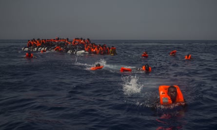 African migrants try to reach a rescue boat in the Mediterranean Sea, about 12 miles north of Sabratha, Libya, on 23 July 2017.